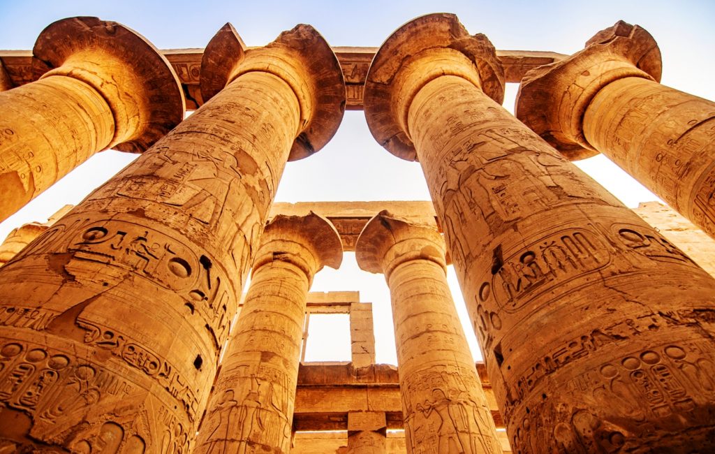 EXPLORING EGYPT - KARNAK TEMPLE - Massive columns inside beautiful Egyptian landmark with hieroglyphics, and ancient symbols. Famous landmark in the world near the Nile River and Luxor, Egypt